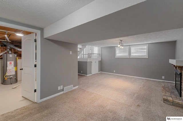 basement with carpet, water heater, and a textured ceiling