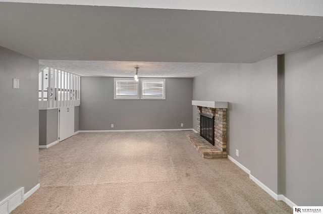 unfurnished living room with carpet flooring, a brick fireplace, and a textured ceiling