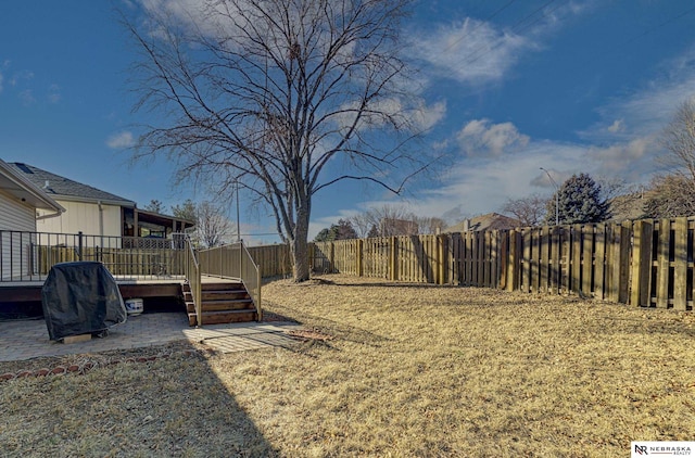 view of yard featuring a wooden deck and a patio