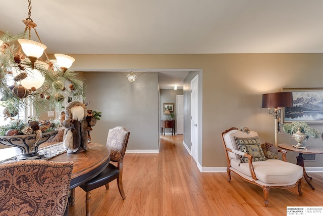 dining area with light hardwood / wood-style flooring and a chandelier