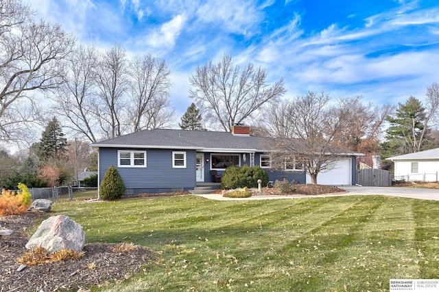 ranch-style house featuring a garage and a front lawn