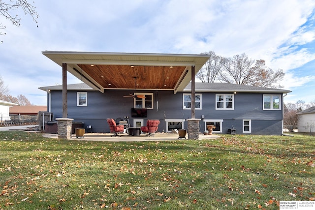 back of property with a yard, a patio area, and ceiling fan