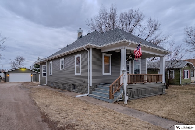 bungalow-style home featuring an outbuilding, a garage, and a porch