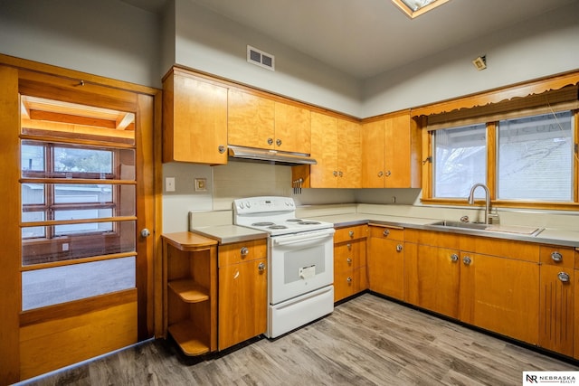 kitchen with white electric stove, sink, and light hardwood / wood-style flooring