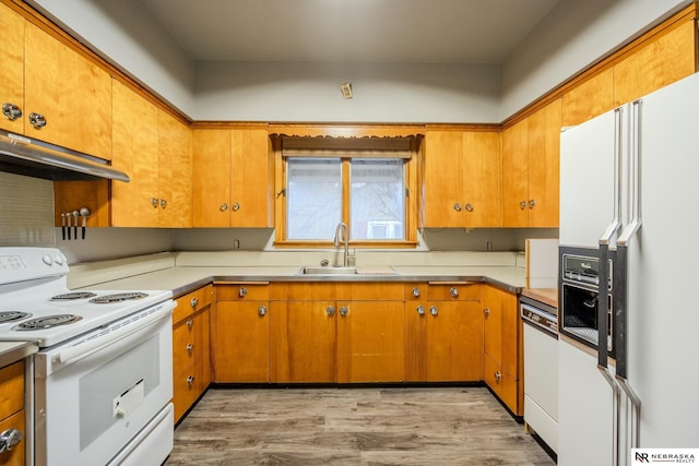 kitchen with range hood, sink, white appliances, and light hardwood / wood-style floors