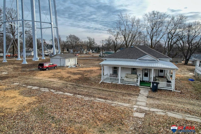 view of front of home with an outbuilding, a garage, and a porch