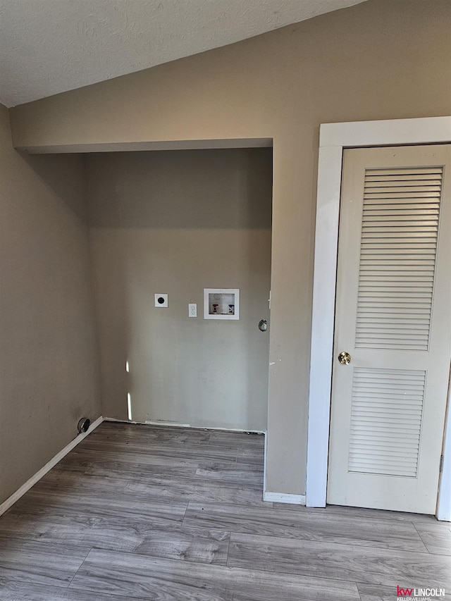 clothes washing area with electric dryer hookup, washer hookup, and light hardwood / wood-style flooring