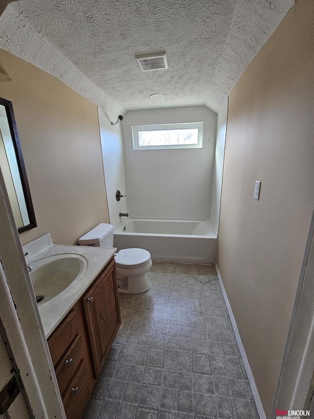 full bathroom featuring lofted ceiling, washtub / shower combination, vanity, a textured ceiling, and toilet