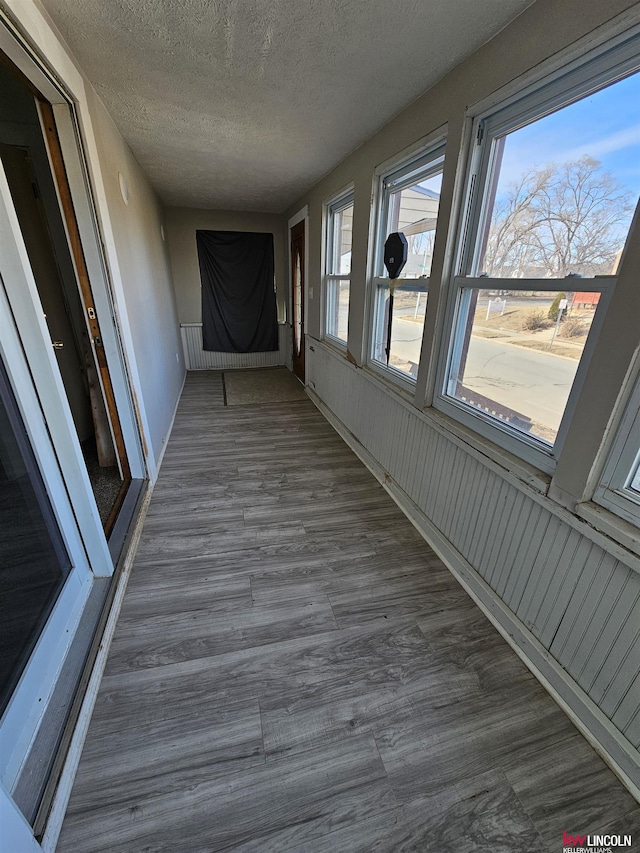 corridor featuring dark wood-type flooring and a textured ceiling