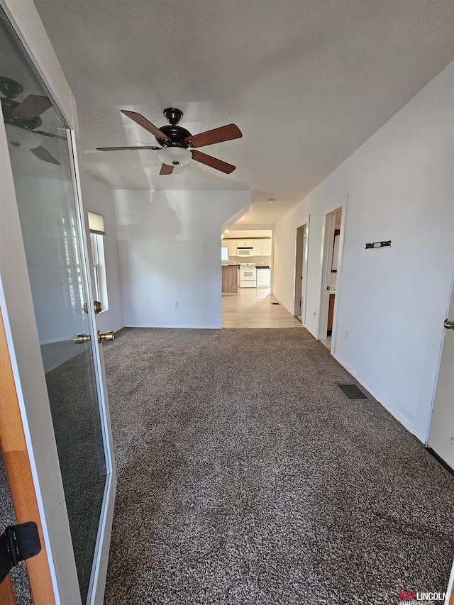 unfurnished room with carpet flooring, a textured ceiling, and ceiling fan