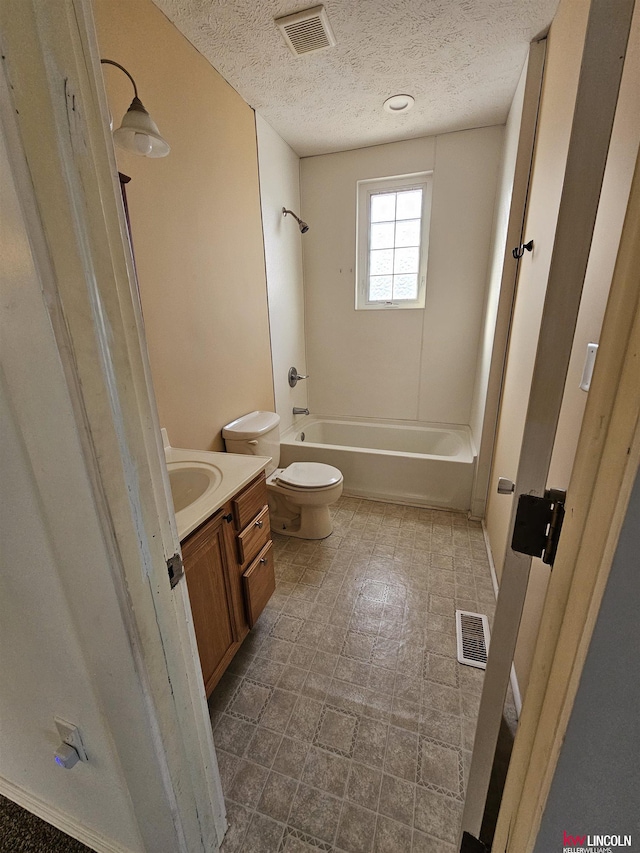 full bathroom featuring vanity, tub / shower combination, a textured ceiling, and toilet