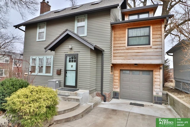 view of front of home with a garage and central air condition unit