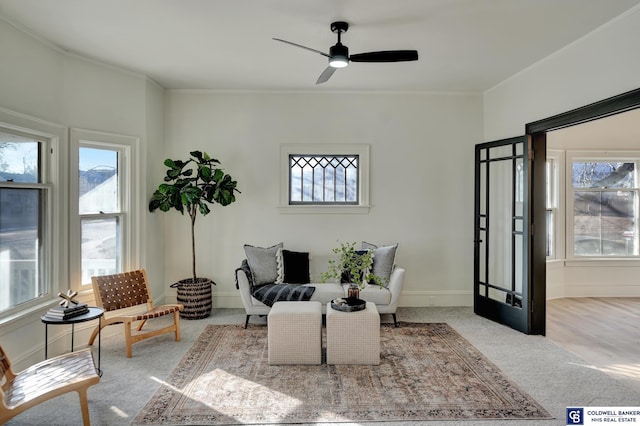 living room with light carpet, crown molding, and ceiling fan