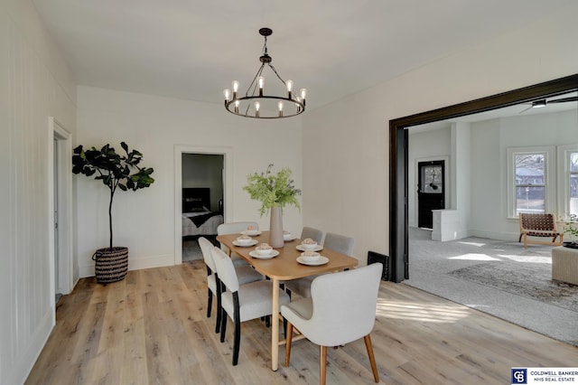 dining space with an inviting chandelier and light hardwood / wood-style flooring