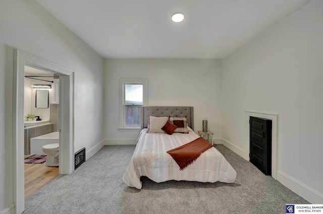 carpeted bedroom featuring ensuite bath