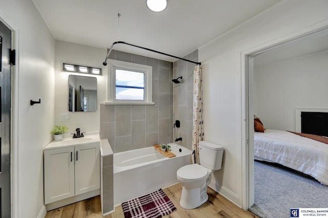 full bathroom featuring shower / bathtub combination with curtain, vanity, hardwood / wood-style flooring, and toilet