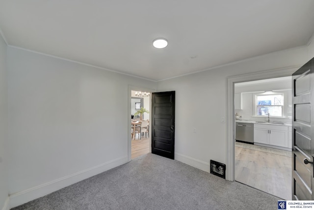 unfurnished bedroom featuring crown molding, sink, and light colored carpet