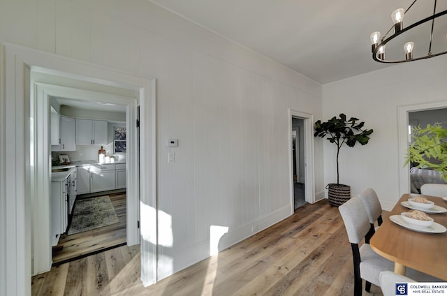 dining area featuring light hardwood / wood-style floors and a chandelier