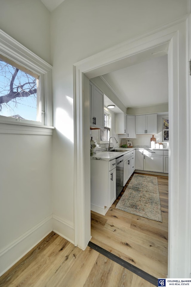 kitchen featuring dishwasher, a wealth of natural light, white cabinets, and light wood-type flooring