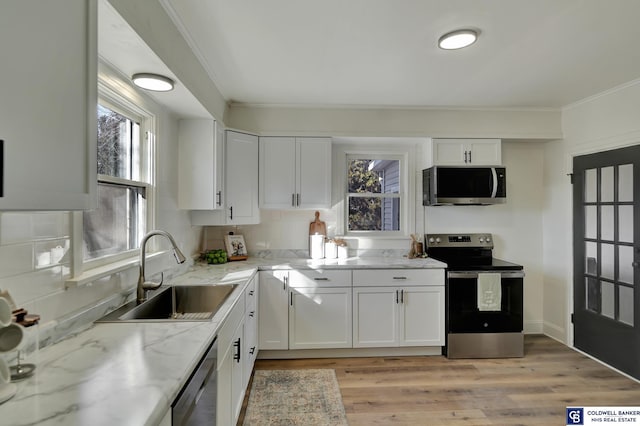 kitchen with light stone counters, sink, stainless steel appliances, and white cabinets