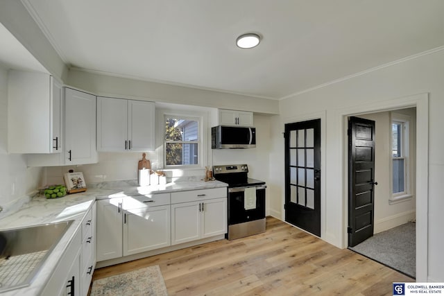 kitchen with stainless steel appliances, white cabinetry, sink, and ornamental molding