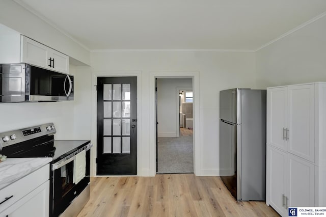 kitchen featuring white cabinetry, ornamental molding, stainless steel appliances, light stone countertops, and light wood-type flooring