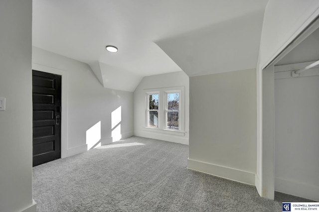 additional living space with vaulted ceiling and carpet floors