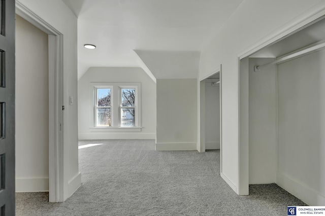 interior space featuring lofted ceiling and light carpet