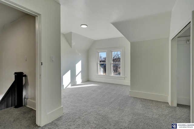 bonus room with vaulted ceiling and carpet