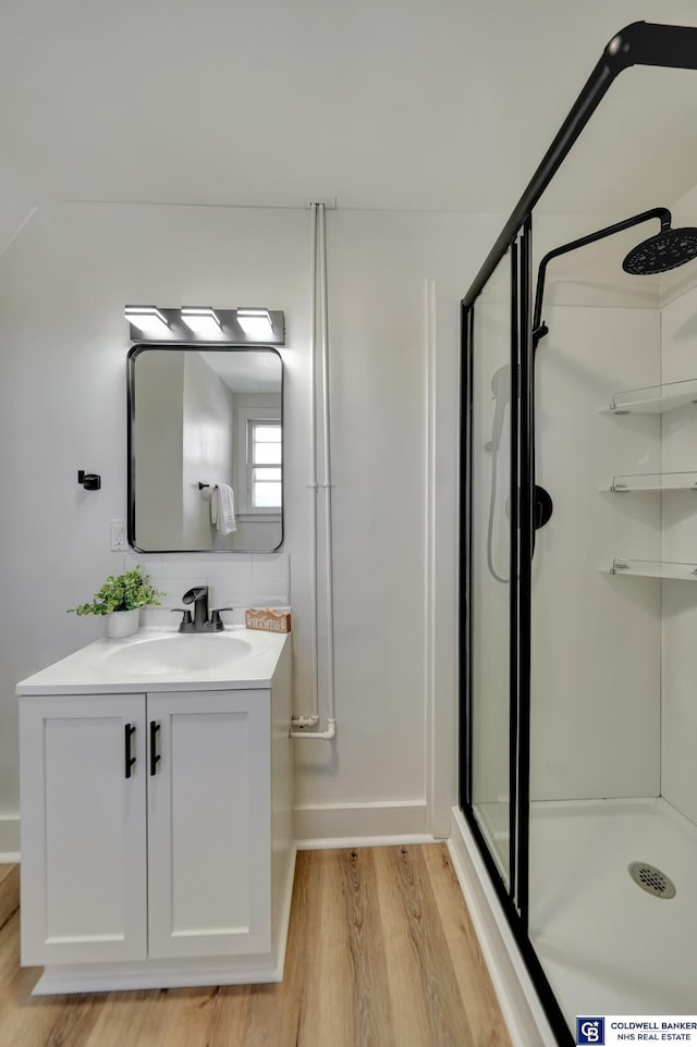 bathroom featuring an enclosed shower, vanity, and hardwood / wood-style floors