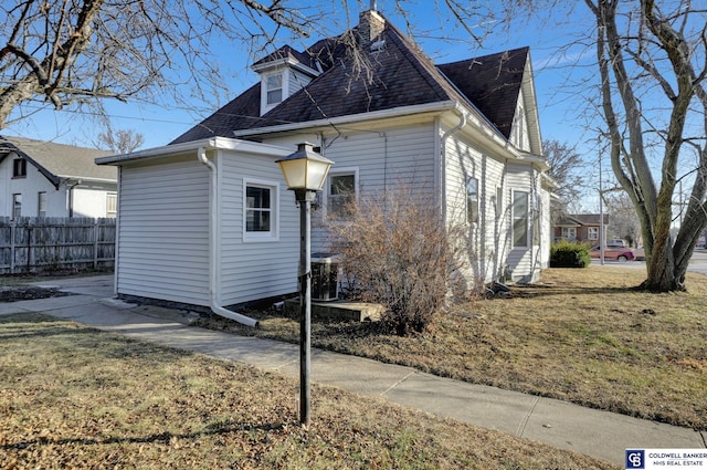 view of property exterior with a yard and central air condition unit