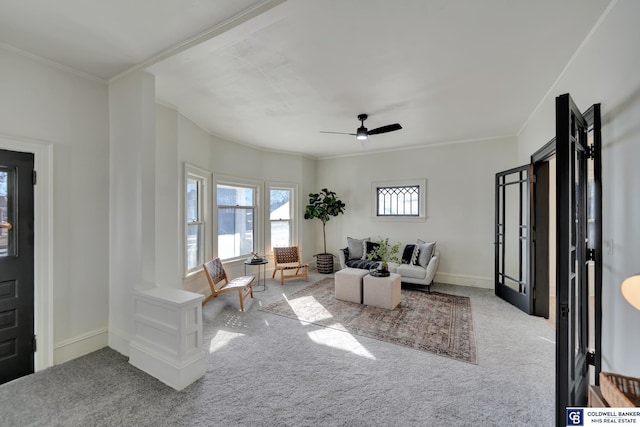 living room with crown molding, light colored carpet, and ceiling fan