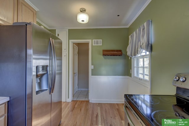 kitchen with stainless steel appliances, crown molding, light brown cabinets, and light hardwood / wood-style floors