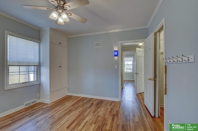 empty room featuring ceiling fan, ornamental molding, and light wood-type flooring