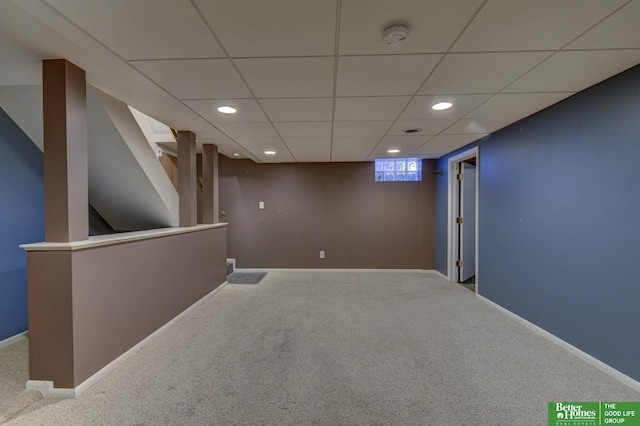 basement featuring carpet floors and a drop ceiling