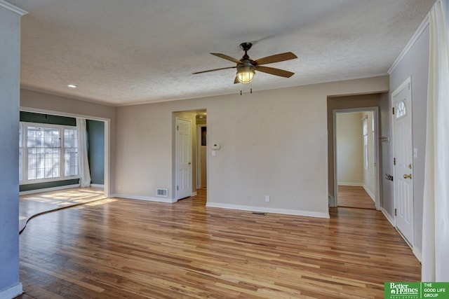 spare room with crown molding, ceiling fan, a textured ceiling, and light wood-type flooring