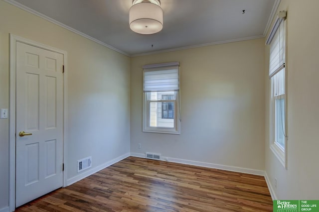 spare room featuring ornamental molding and dark hardwood / wood-style floors