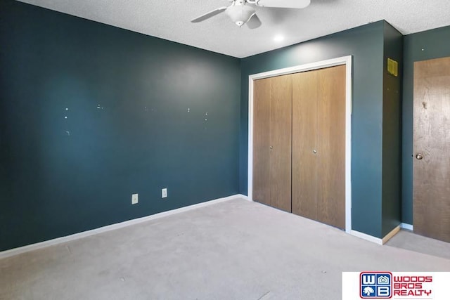 unfurnished bedroom with ceiling fan, carpet flooring, a closet, and a textured ceiling