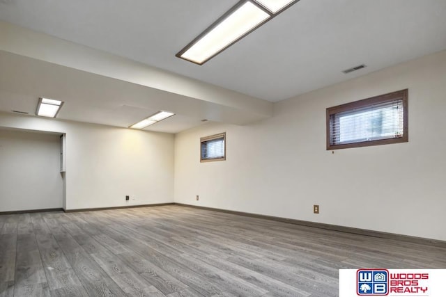 basement featuring a healthy amount of sunlight and hardwood / wood-style floors