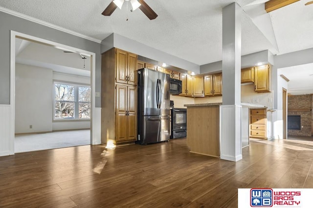 kitchen with electric range oven, dark hardwood / wood-style floors, stainless steel fridge, ceiling fan, and a fireplace