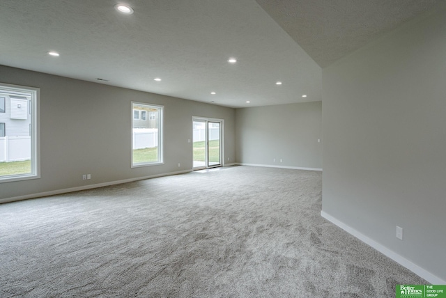 carpeted spare room featuring a textured ceiling