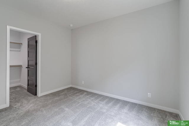 unfurnished bedroom featuring a walk in closet, light carpet, and a closet