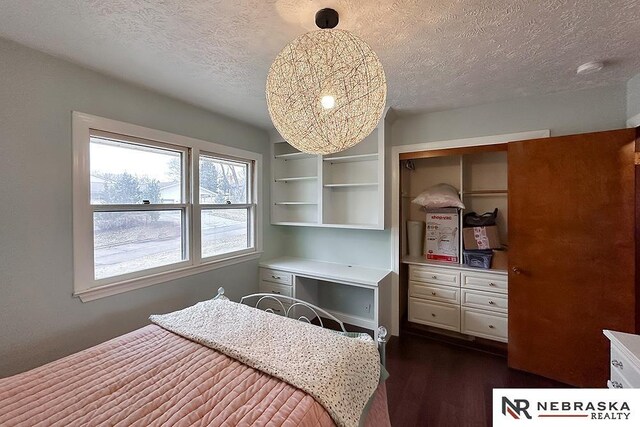 bedroom featuring dark hardwood / wood-style flooring, a textured ceiling, and a closet