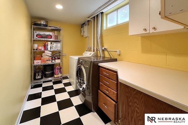 clothes washing area with cabinets and independent washer and dryer