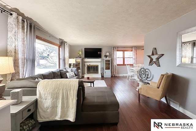 living room with dark hardwood / wood-style floors and a textured ceiling