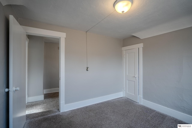 unfurnished room with dark colored carpet