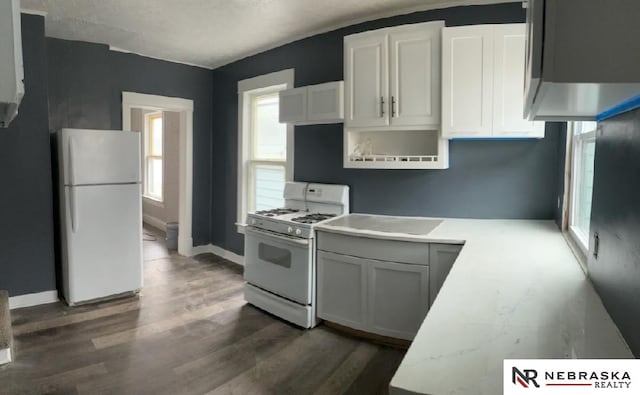 kitchen featuring white cabinetry, dark hardwood / wood-style floors, and white appliances