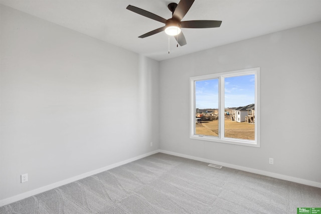 carpeted spare room with ceiling fan