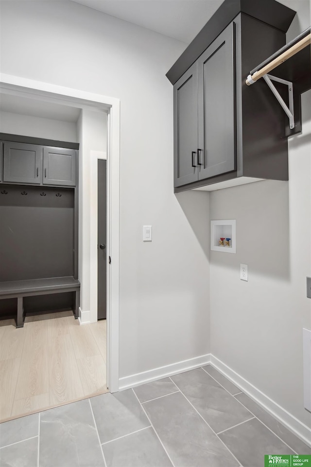 clothes washing area featuring cabinets, washer hookup, and tile patterned floors