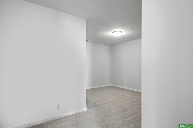 unfurnished room featuring light colored carpet and a textured ceiling